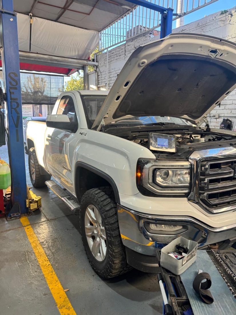 Camioneta GMC Sierra en rampa recibiendo servicio en Taller Montaño